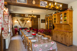 Salle à manger, table préparée pour une bonne fondue, coin salon au fond