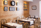 Salle à manger avec au mur des vieilles photos et une pendule ancienne