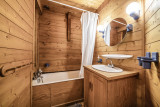 Salle de bains tout en bois avec baignoire, lavabo et son meuble, miroir
