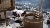 Bain nordique sur la terrasse enneigée avec vue sur le village