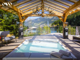 Bain à remous en été sous sa pergola, terrasse autour et vue sur le lac de Vonnes