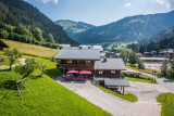 Extérieur du chalet en été avec terrasse et vue sur le village