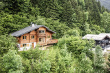 Le chalet en été entouré de verdure