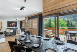 Salle à manger avec sa grande table, accès au balcon par grandes baies vitrées