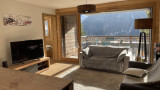 Séjour avec grande baie vitrée donnant vue sur les montagnes et accès au balcon