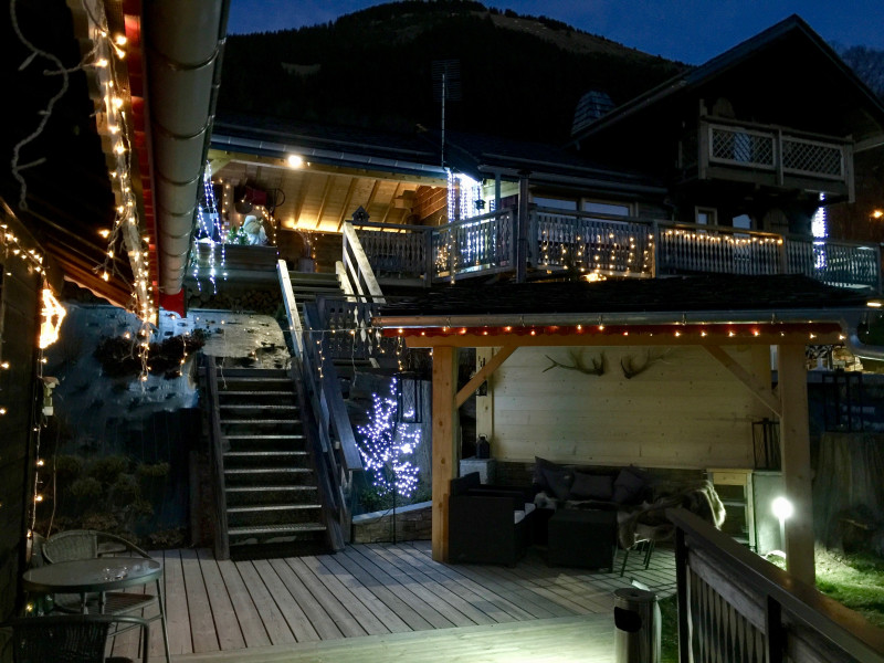 Vue de la terrasse de nuit avec guirlandes lumineuses, coin détente